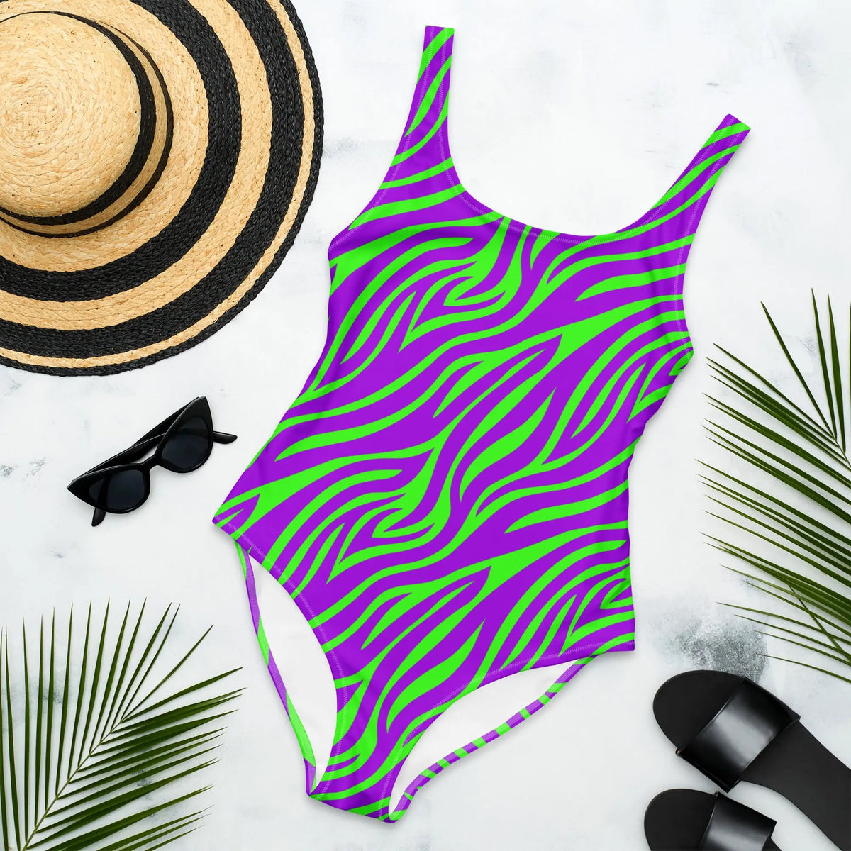 Purple and green neon zebra print one-piece swimsuit with high-cut legs and scoop back, styled in a bold Y2K retro design.