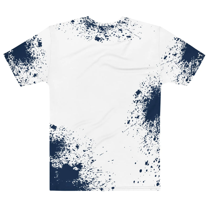White t-shirt with bold navy text reading ‘Nittany Lions’ across the chest, featuring an all-over blue paint splatter design on the sleeves and lower body.