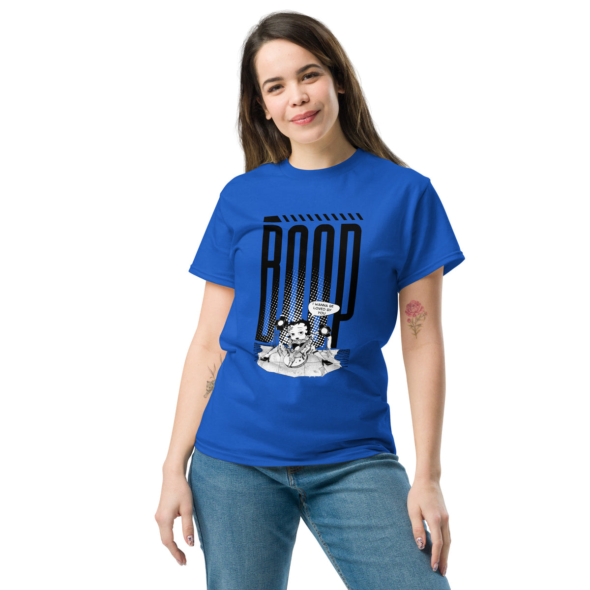 Woman wearing a royal blue graphic tee with a Betty Boop-inspired rock star design, styled with blue denim jeans