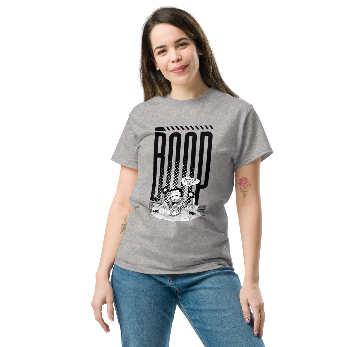 Woman wearing a sport grey graphic tee with a Betty Boop-inspired rock star design, styled with blue denim jeans