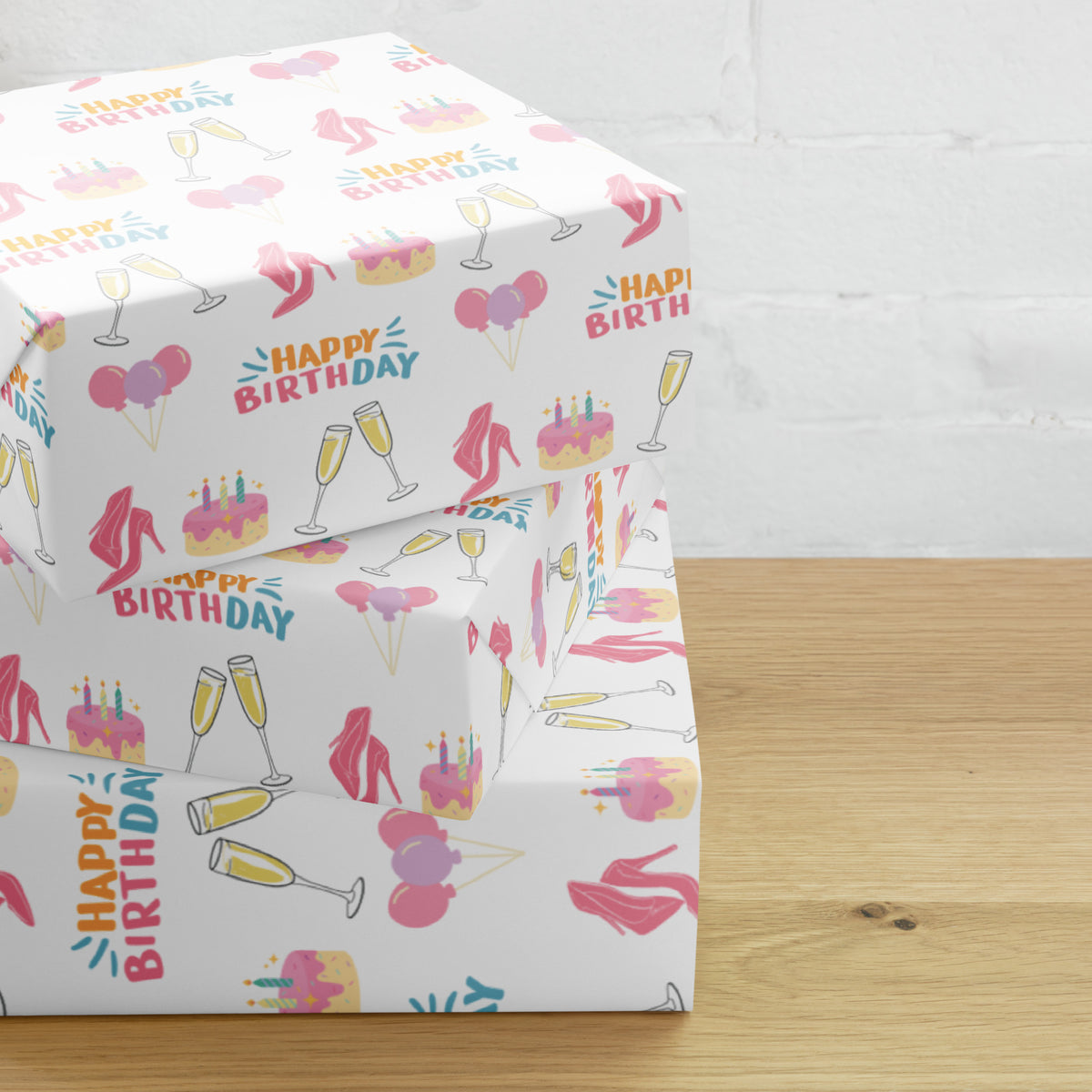 White birthday wrapping paper with pink heels, cakes, balloons, champagne glasses, and colorful Happy Birthday lettering