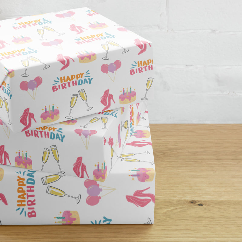 White birthday wrapping paper with pink heels, cakes, balloons, champagne glasses, and colorful Happy Birthday lettering