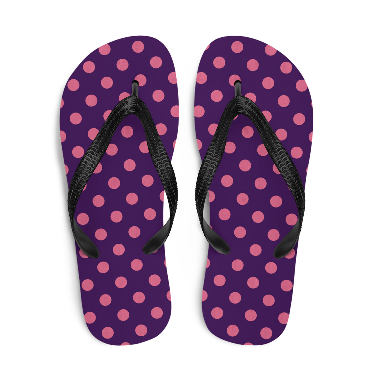 Pink polka dot flip-flops on a purple background with black straps