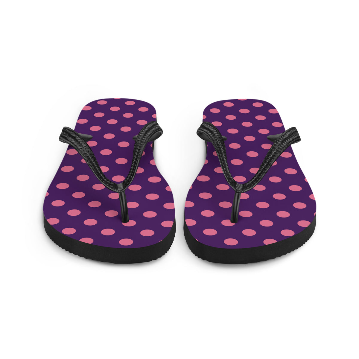 Pink polka dot flip-flops on a purple background with black straps