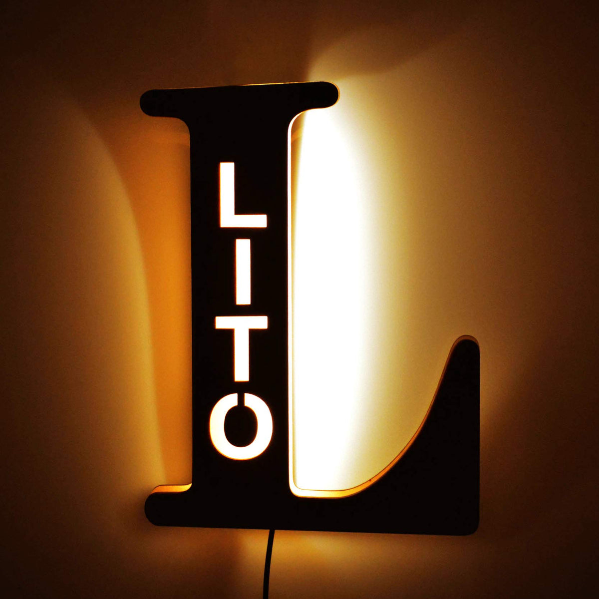Personalized wooden alphabet LED night light with hollow-engraved letter and custom name illuminated by a soft ambient glow