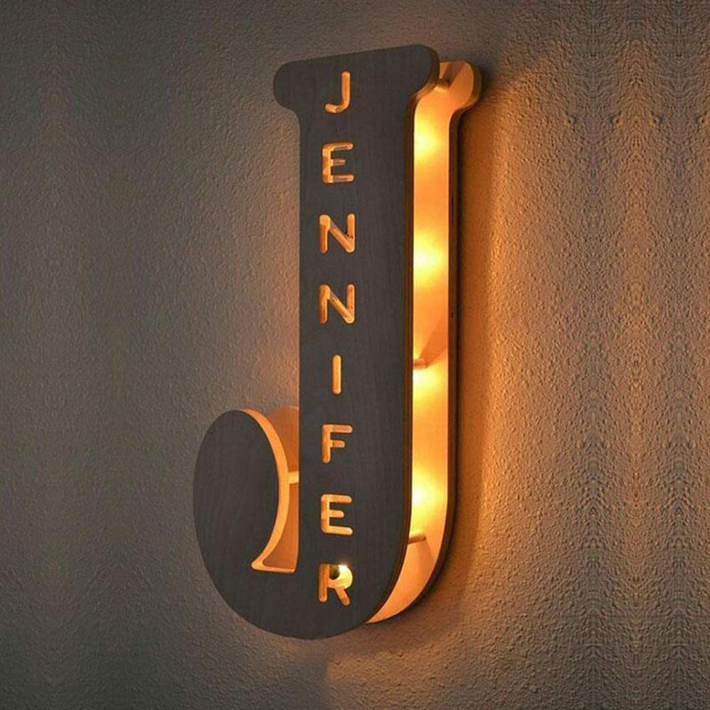 Personalized wooden alphabet LED night light with hollow-engraved letter and custom name illuminated by a soft ambient glow