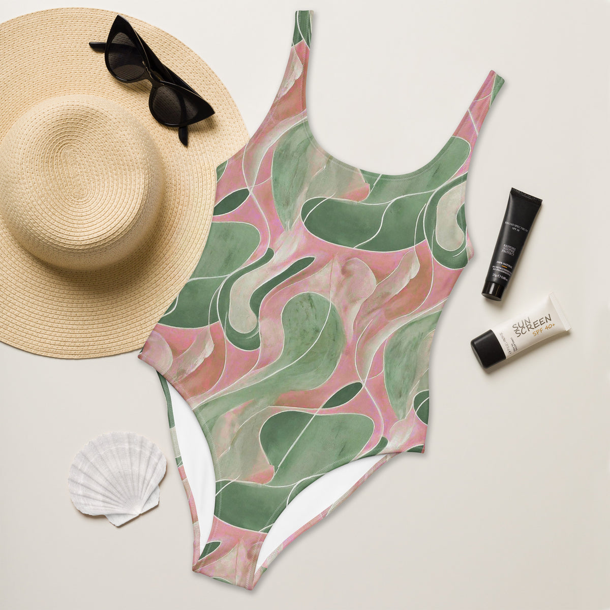 Model wearing a Pink and green retro abstract marble-print one-piece swimsuit with scoop neckline and cheeky fit
