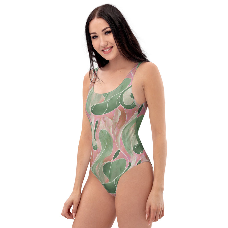 Model wearing a Pink and green retro abstract marble-print one-piece swimsuit with scoop neckline and cheeky fit
