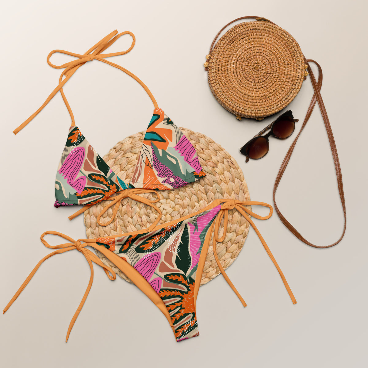Tropical print two-piece string bikini with tangerine ties, triangle top, and tie-side bottoms