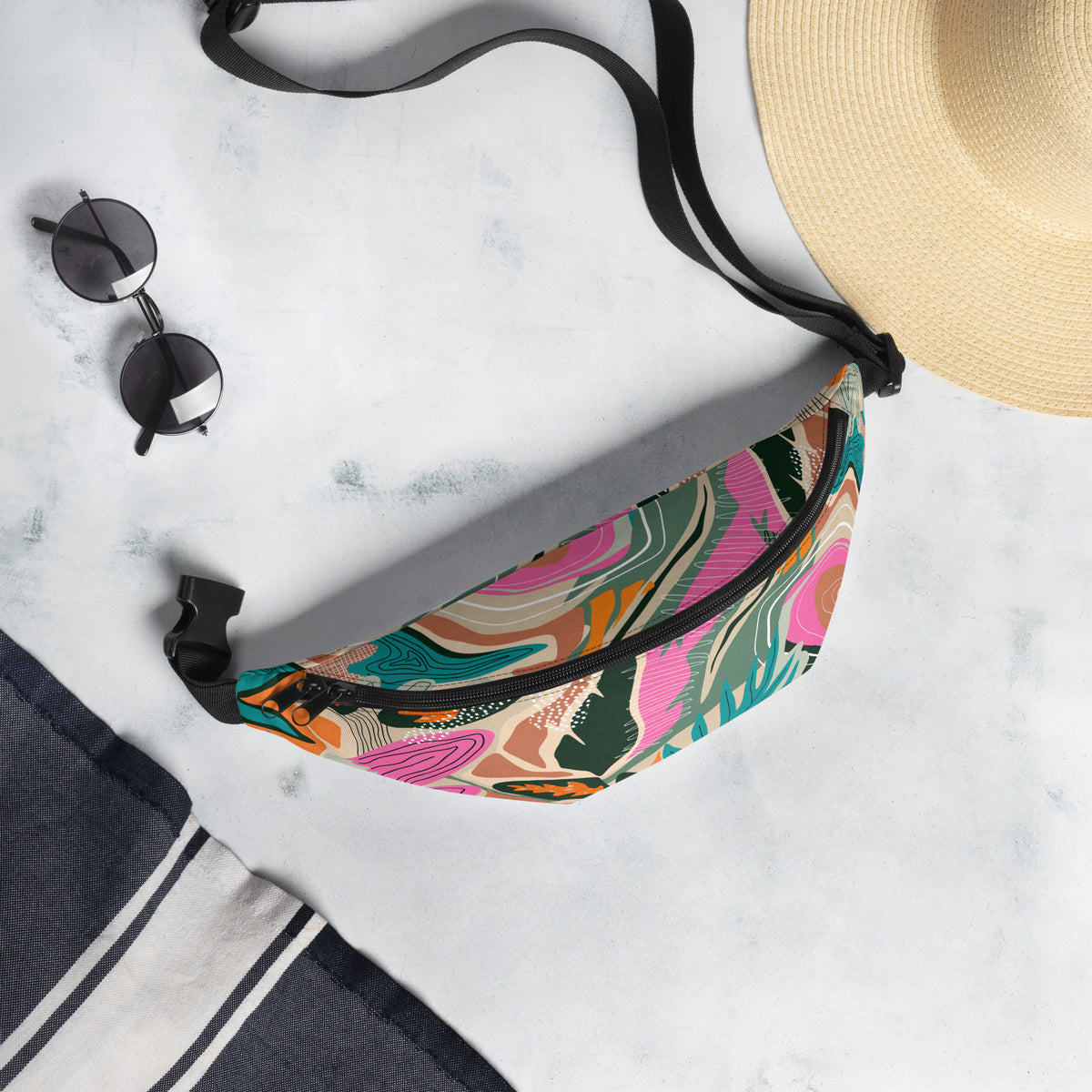 Tropical print fanny pack with tangerine, pink, teal, and green tones worn as a belt bag