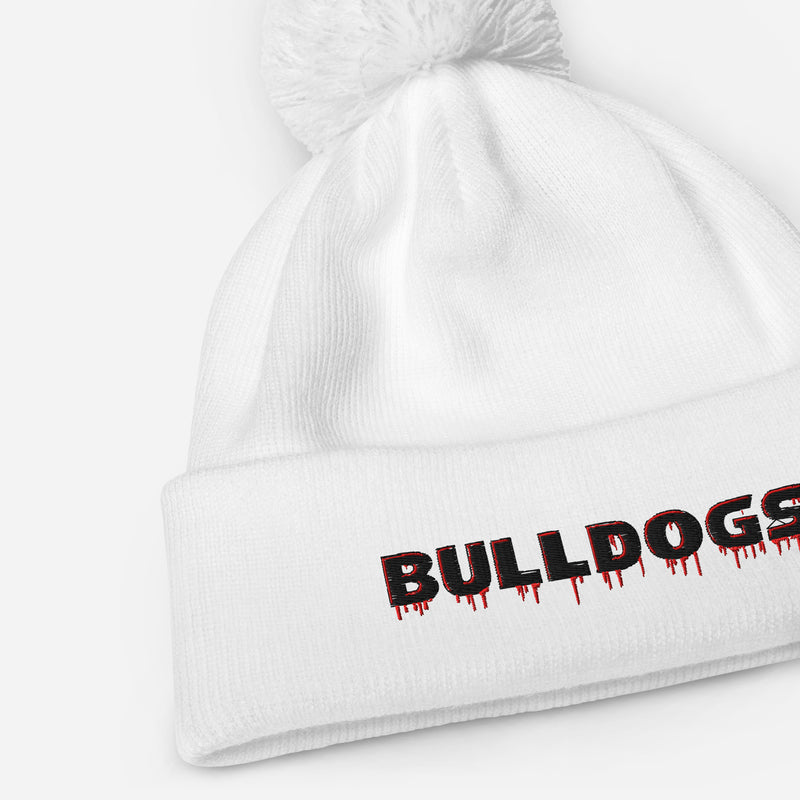 A white Bulldogs-inspired pom pom beanie featuring bold red-and-black embroidered lettering, soft-touch acrylic, a double-layer knit, and classic cuffed styling.