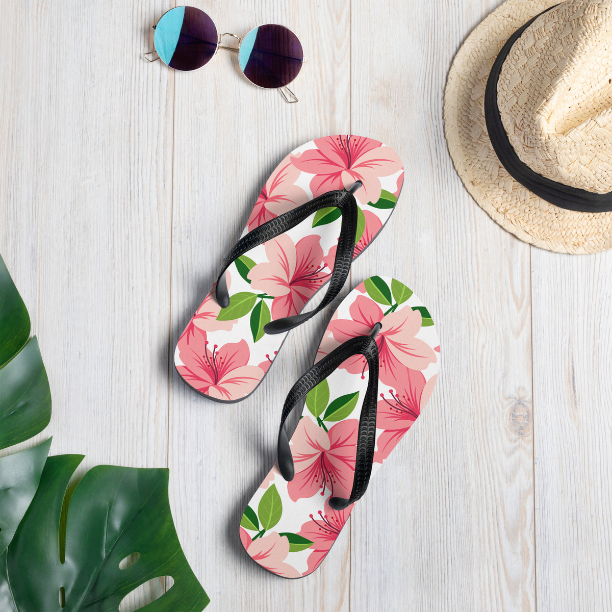 Pink floral print flip-flops with black straps and tropical flower design